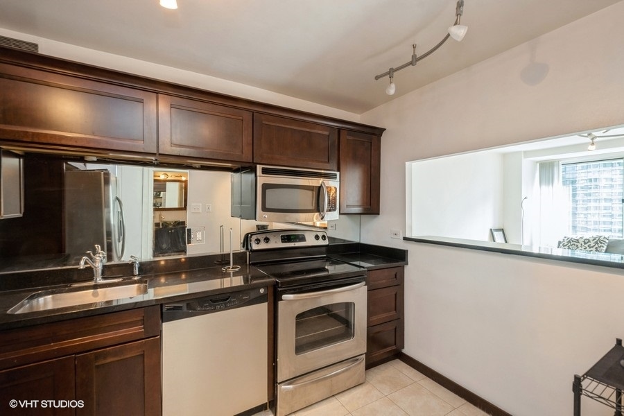 211 East Ohio Street, Unit 2012 Chicago, IL 60611 - Photo 6 of 19 a kitchen with stainless steel appliances a stove sink and cabinets