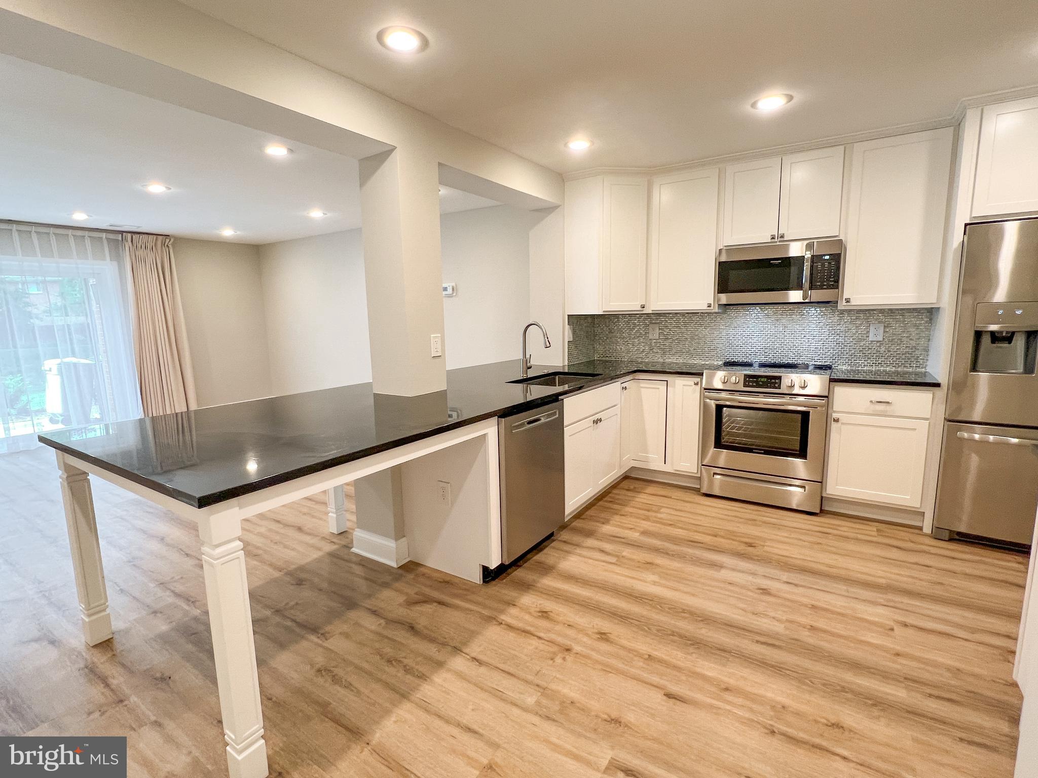 36 Pennydog Court Silver Spring, MD 20902 - Photo 20 of 27 a large kitchen with stainless steel appliances granite countertop a sink a stove and a refrigerator