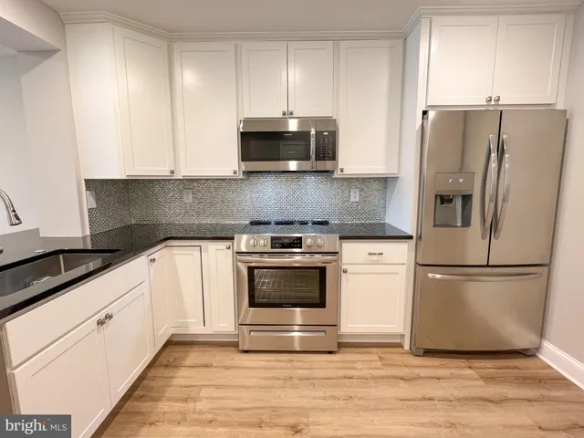 a kitchen with cabinets and stainless steel appliances