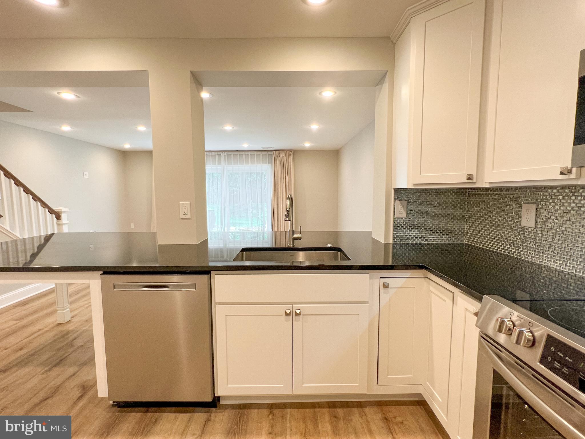 36 Pennydog Court Silver Spring, MD 20902 - Photo 22 of 27 a kitchen with granite countertop a sink a stove and cabinets