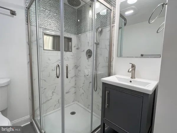 a bathroom with a sink mirror and shower