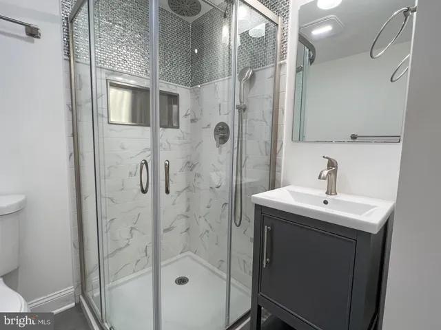 a bathroom with a sink mirror and shower