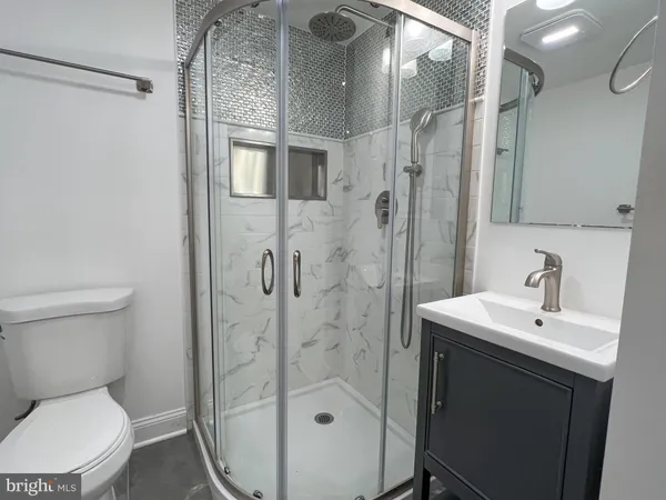 a bathroom with a sink a toilet and shower