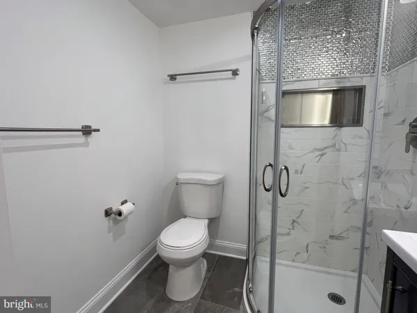 a bathroom with a toilet and a shower