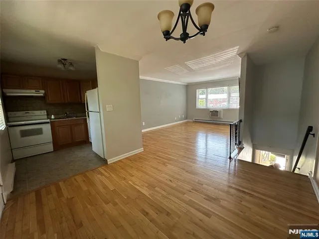 a view of empty room with kitchen and window