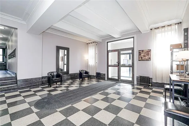a living room with a black white checkered floor with couches chair and a coffee table
