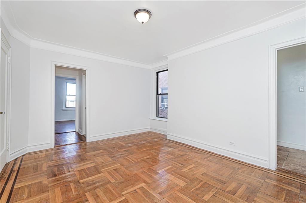 9524 Fort Hamilton Parkway, Unit 601 Brooklyn, NY 11209 - Photo 5 of 13 an empty room with wooden floor and windows