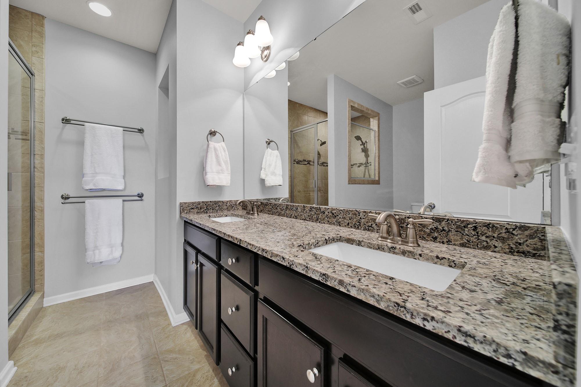 212 Butterfly Place Tega Cay, SC 29708 - Photo 19 of 35 a bathroom with a granite countertop sink a large mirror and a shower