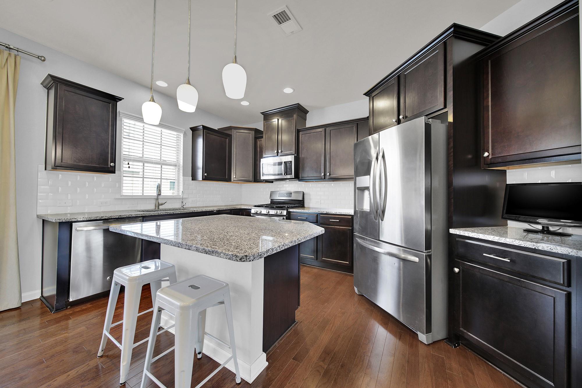 212 Butterfly Place Tega Cay, SC 29708 - Photo 9 of 35 a kitchen with stainless steel appliances granite countertop a refrigerator a stove a sink and a microwave