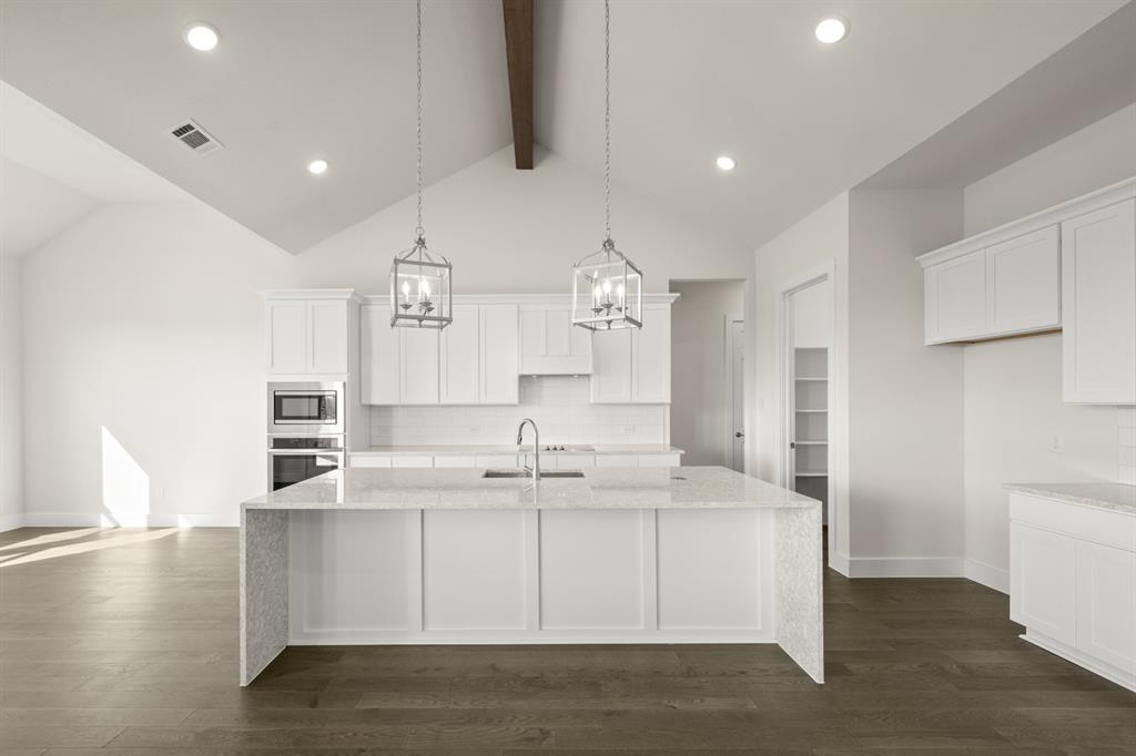 1300 Green Ridge Drive Weatherford, TX 76085 - Photo 8 of 24 a large white kitchen with kitchen island a sink stainless steel appliances and cabinets
