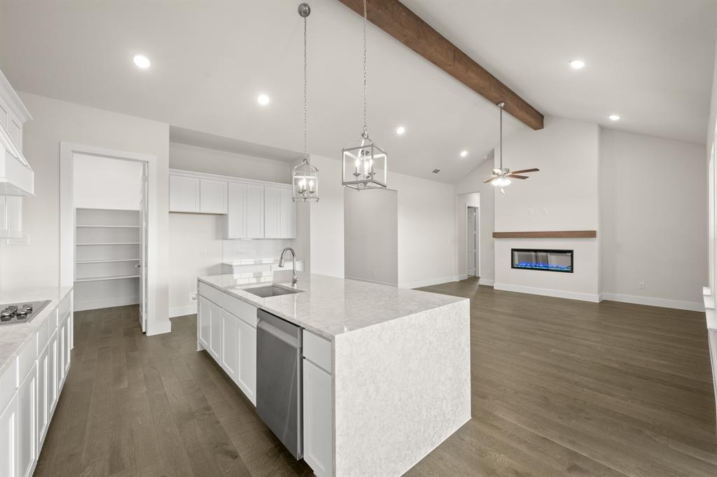 1300 Green Ridge Drive Weatherford, TX 76085 - Photo 10 of 24 a large white kitchen with a refrigerator a sink dishwasher a dining table and chairs with wooden floor
