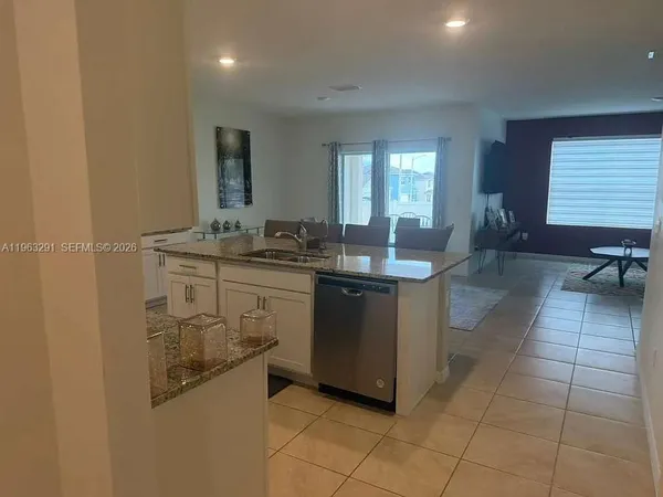 a kitchen with a sink counter top space and living room