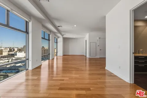 a view of a kitchen with a refrigerator and an empty room