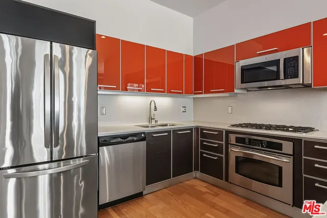 a kitchen with stainless steel appliances a stove a microwave and a sink