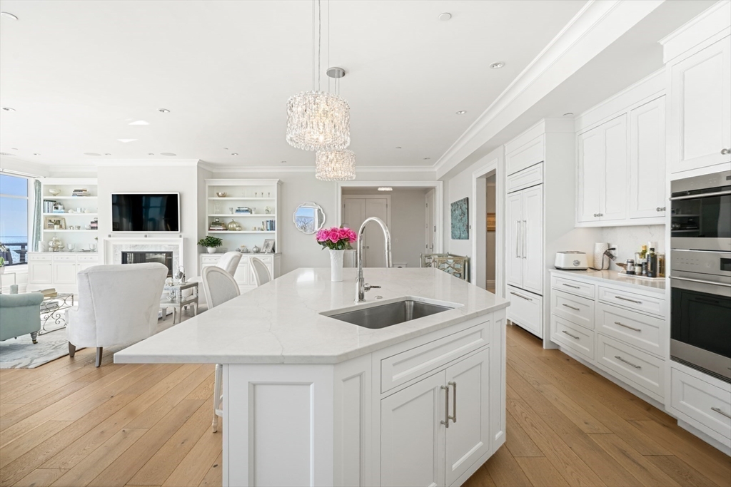 35 Littles Point Road, Unit S201 Swampscott, MA 01907 - Photo 11 of 36 a kitchen with stainless steel appliances granite countertop a sink dishwasher and white cabinets with wooden floor