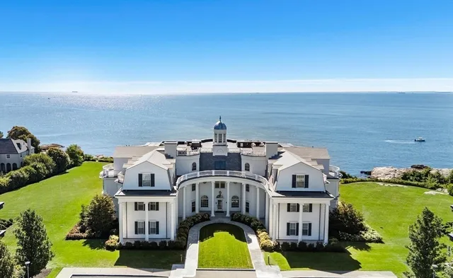 an aerial view of residential houses with outdoor space and ocean view