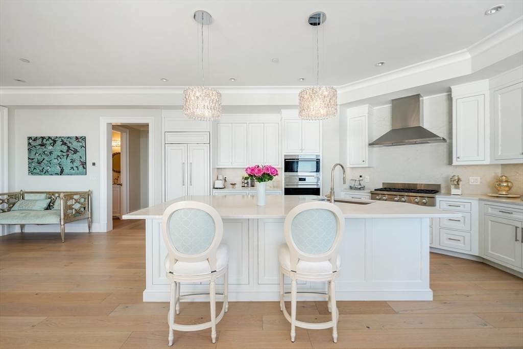 35 Littles Point Road, Unit S201 Swampscott, MA 01907 - Photo 9 of 36 a kitchen with stainless steel appliances granite countertop a stove a sink dishwasher a dining table and chairs with wooden floor