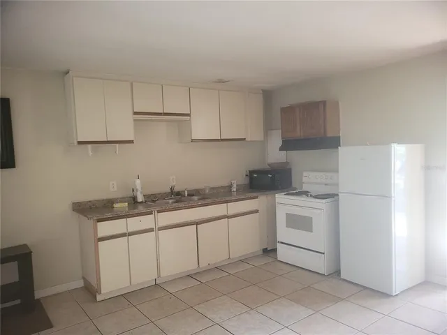 a kitchen with white cabinets appliances and sink
