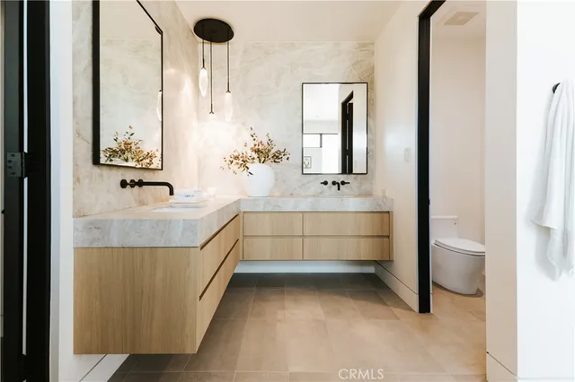 a bathroom with double vanity and a mirror