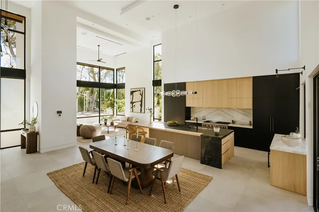 a kitchen with stainless steel appliances granite countertop a stove refrigerator and chairs