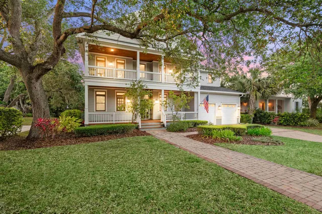 a front view of a house with a yard and trees