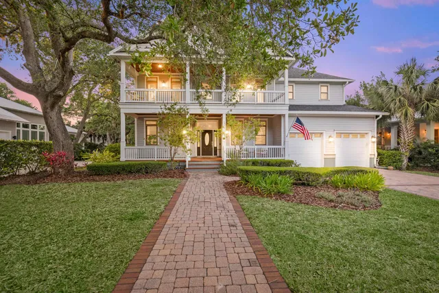 a front view of a house with a yard and trees