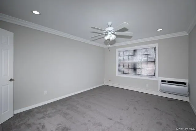 an empty room with windows and ceiling fan