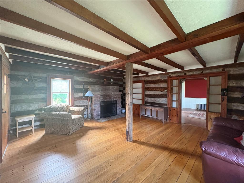7281 Decatur Street New Tripoli, PA 18066 - Photo 6 of 27 Exposed beams and rich hardwood flooring create an inviting atmosphere in this generous living area.