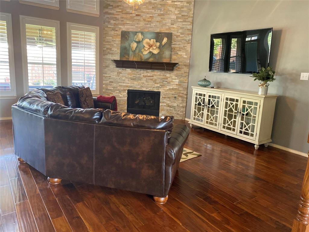 4025 Steepleridge Drive The Colony, TX 75056 - Photo 4 of 23 a living room with furniture a flat screen tv and a fireplace