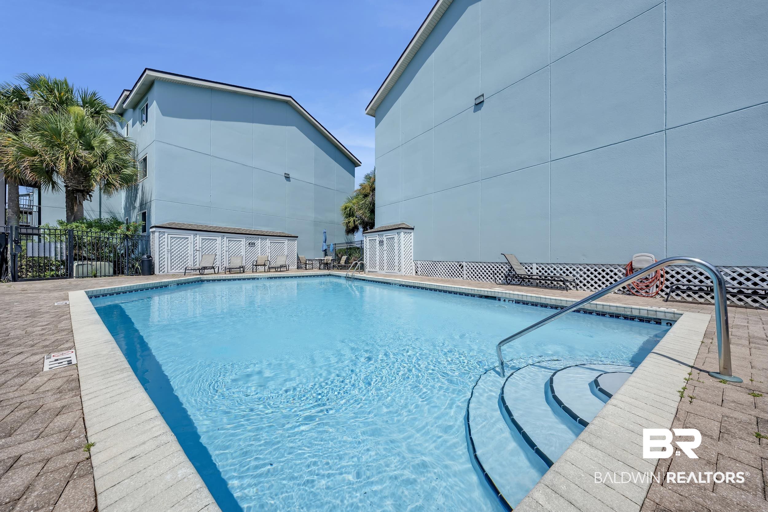 14100 River Road, Unit 211 Pensacola, FL 32507 - Photo 6 of 56 Resort-style pool with integrated steps and a stainless steel handrail, surrounded by a paver deck