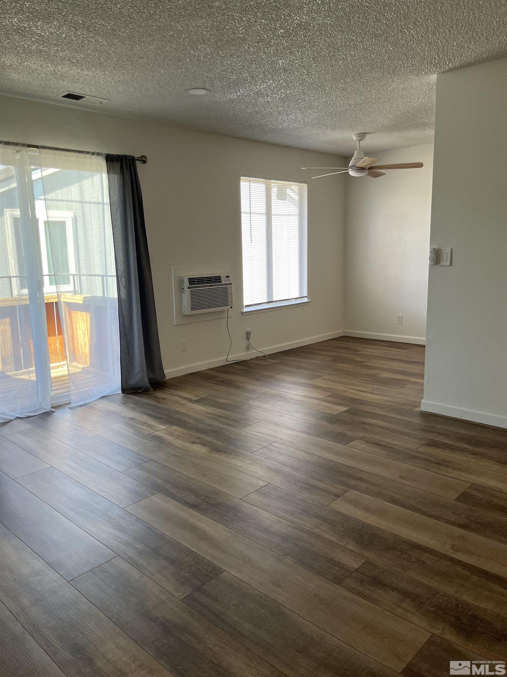 4600 Neil Road, Unit 44 Reno, NV 89502 - Photo 3 of 17 an empty room with wooden floor and windows