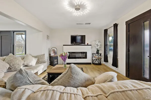 a living room with furniture a flat screen tv and a fireplace
