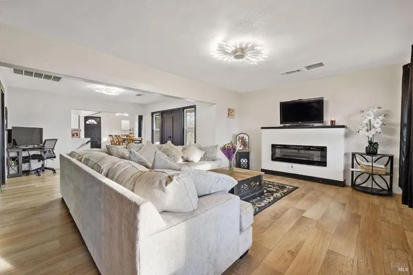a living room with furniture a flat screen tv and a fireplace