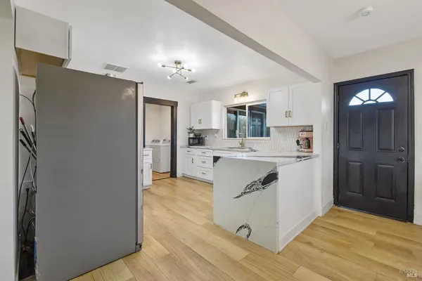 a kitchen with stainless steel appliances granite countertop a refrigerator and a sink