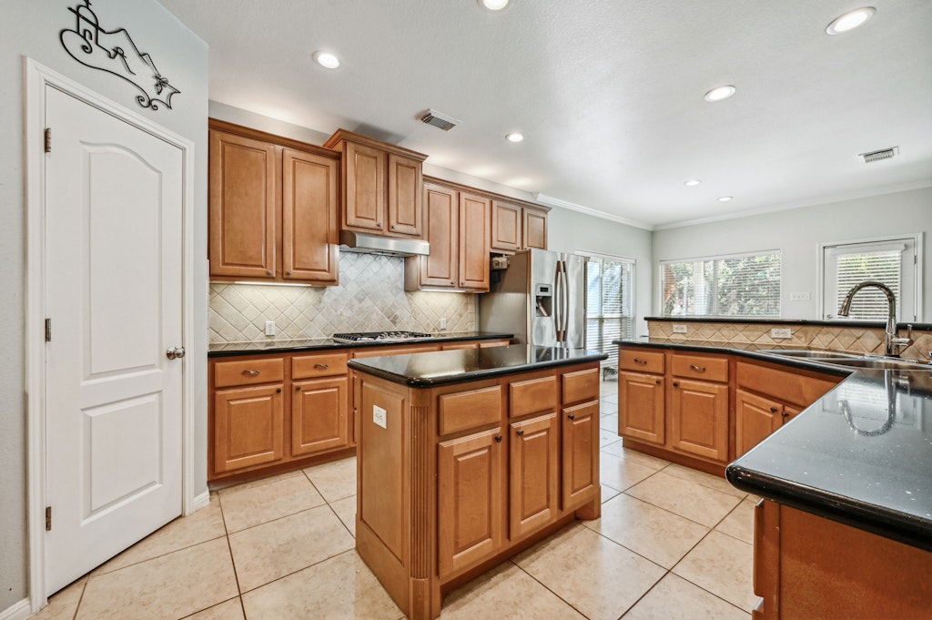 12304 Aralia Ridge Drive Austin, TX 78739 - Photo 13 of 37 a kitchen with stainless steel appliances granite countertop a sink and cabinets