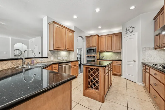 a kitchen with stainless steel appliances granite countertop a sink stove and cabinets