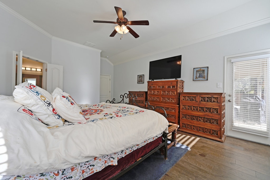 12304 Aralia Ridge Drive Austin, TX 78739 - Photo 17 of 37 a bedroom with a bed and wooden floor
