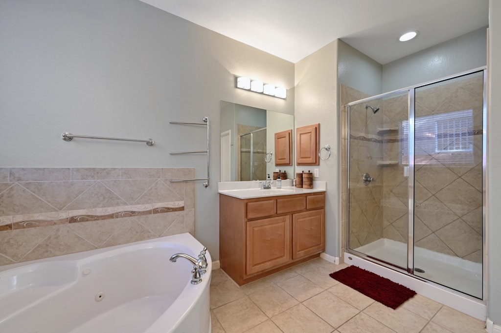 12304 Aralia Ridge Drive Austin, TX 78739 - Photo 19 of 37 a bathroom with a bathtub shower sink and mirror