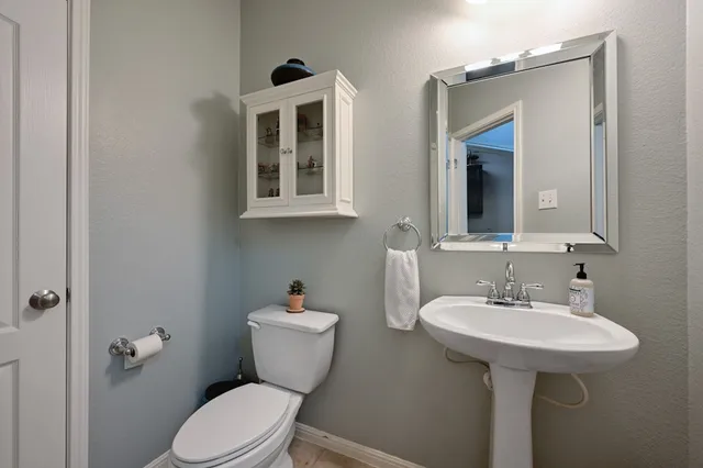a bathroom with a toilet sink and mirror