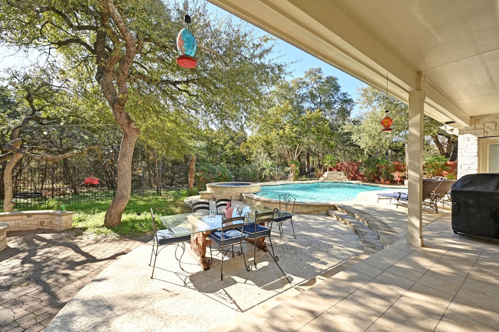 12304 Aralia Ridge Drive Austin, TX 78739 - Photo 32 of 37 a view of a patio with table and chairs and floor to ceiling window