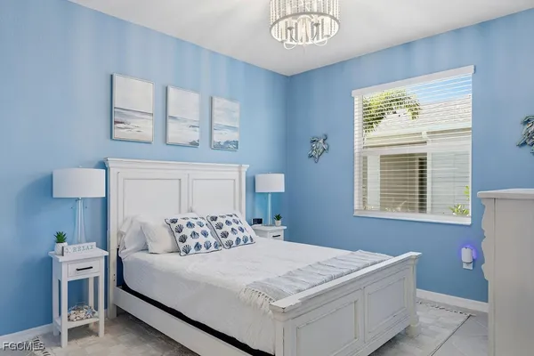 a bedroom with a large bed and a chandelier