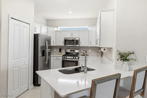 a kitchen with appliances a sink and cabinets
