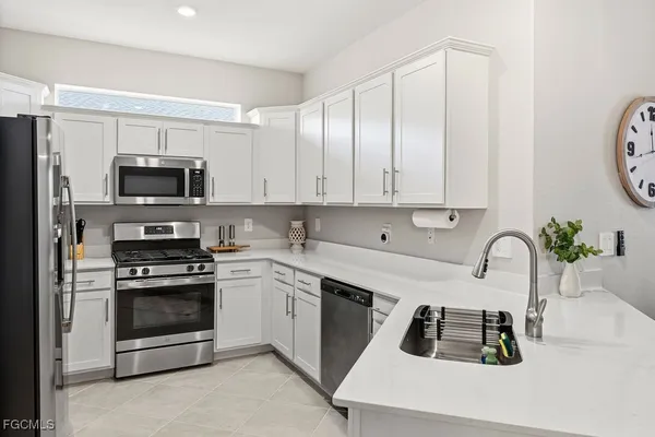 a kitchen with a sink a stove and cabinets