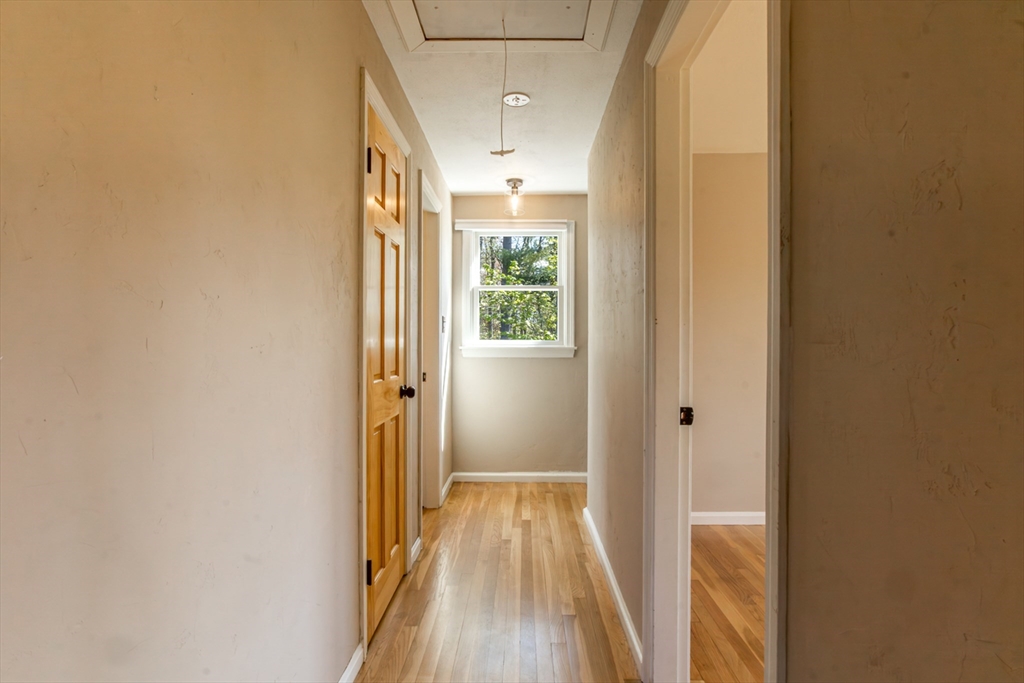 196 Center Street Groveland, MA 01834 - Photo 18 of 32 a view of a hallway with wooden floor and a bathroom