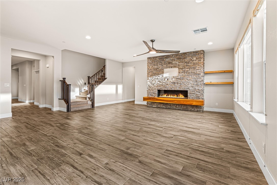 4631 Amazing View Street Las Vegas, NV 89129 - Photo 11 of 94 Unfurnished living room featuring stairway, a fireplace, a ceiling fan, recessed lighting, and wood finished floors