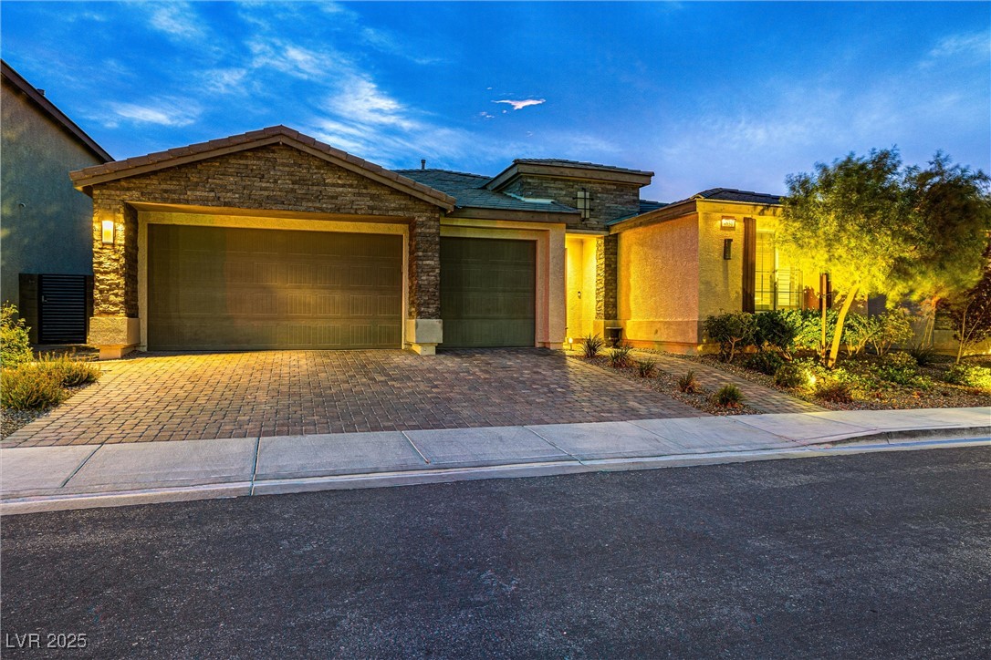 4631 Amazing View Street Las Vegas, NV 89129 - Photo 2 of 94 View of front facade with an attached garage, decorative driveway, stone siding, and stucco siding