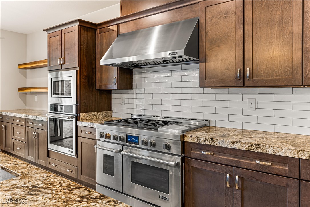 4631 Amazing View Street Las Vegas, NV 89129 - Photo 20 of 94 Kitchen with open shelves, appliances with stainless steel finishes, backsplash, range hood, and dark brown cabinets