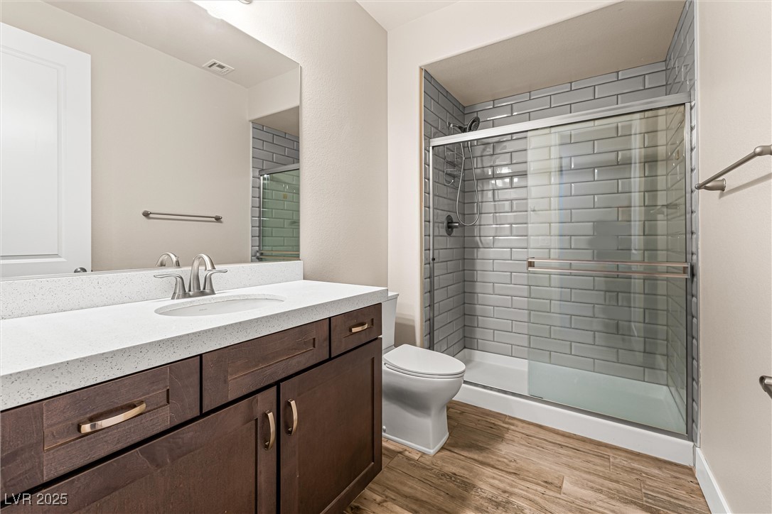 4631 Amazing View Street Las Vegas, NV 89129 - Photo 50 of 94 Bathroom with dark wood-style floors, vanity, and a shower stall
