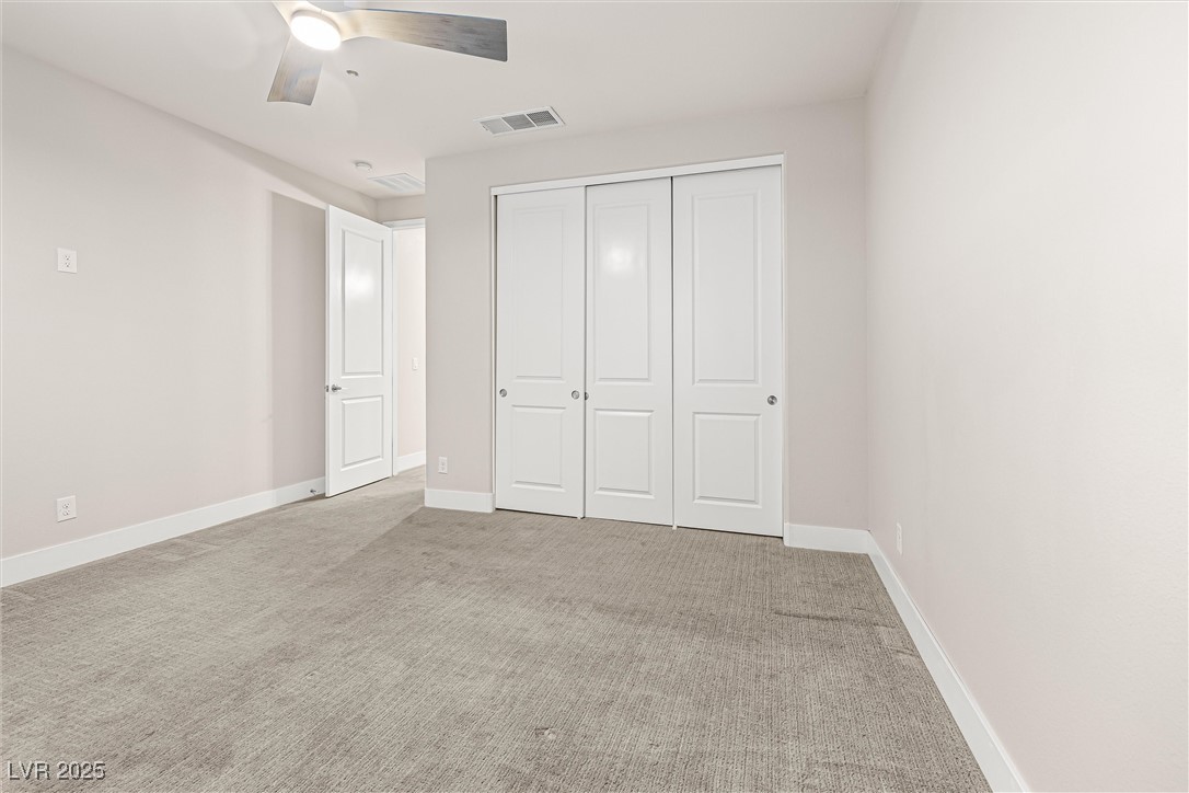 4631 Amazing View Street Las Vegas, NV 89129 - Photo 54 of 94 Unfurnished bedroom with light carpet, a ceiling fan, and a closet