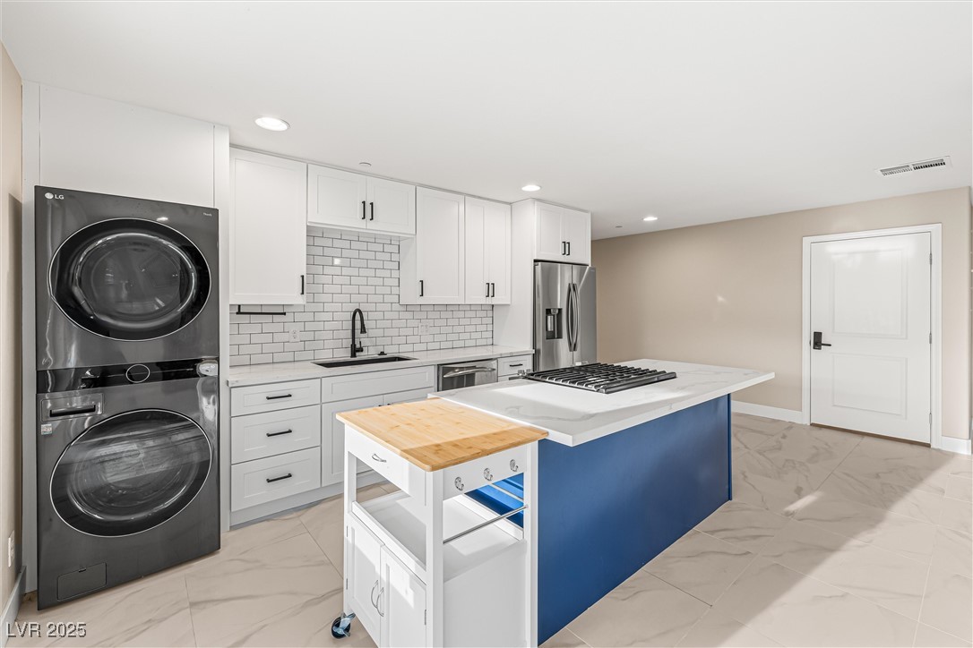 4631 Amazing View Street Las Vegas, NV 89129 - Photo 62 of 94 Kitchen featuring white cabinets, light marble finish flooring, decorative backsplash, stainless steel appliances, and recessed lighting